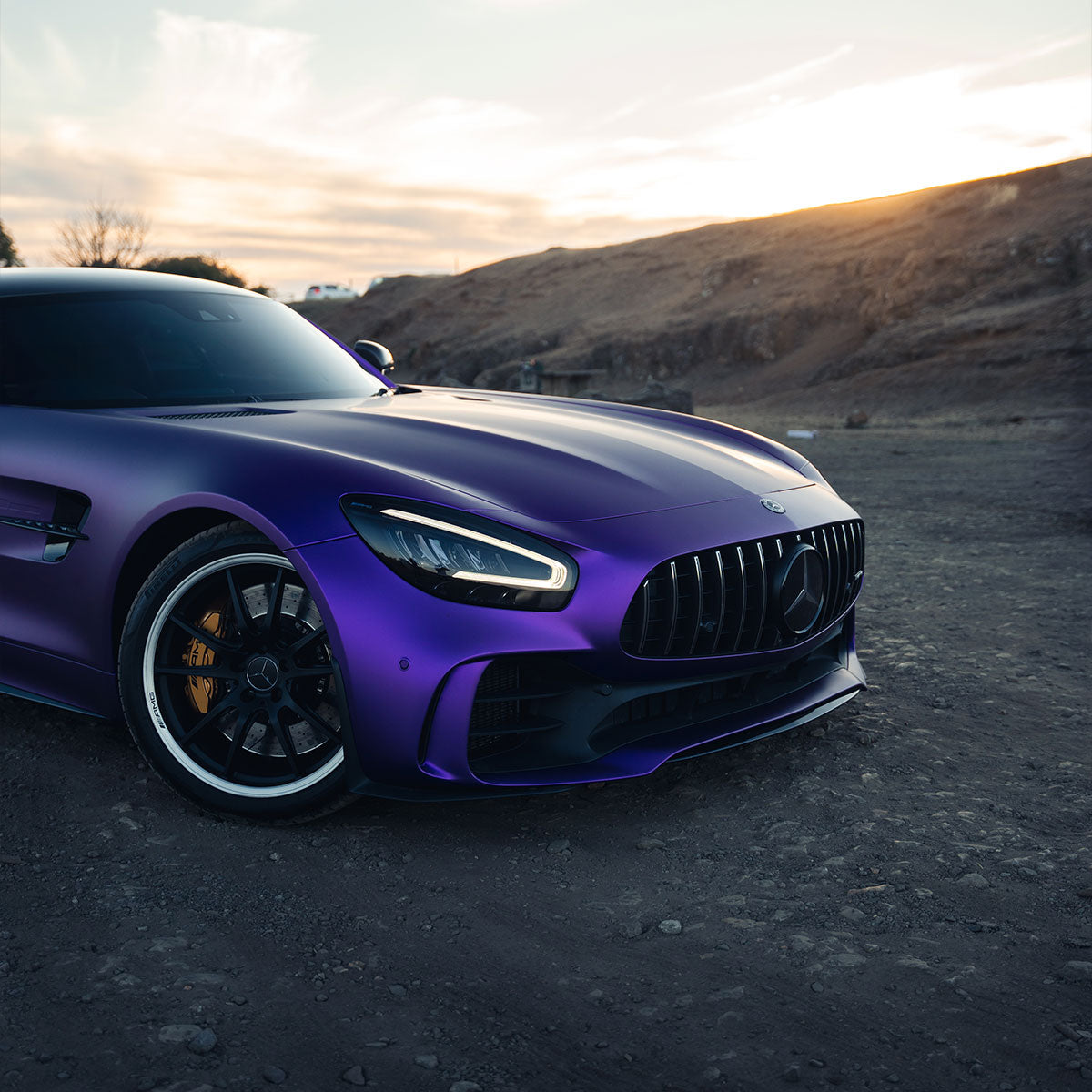 Mercedes-AMG GT wrapped in Matte Metallic Eminence Purple vinyl wrap on road.